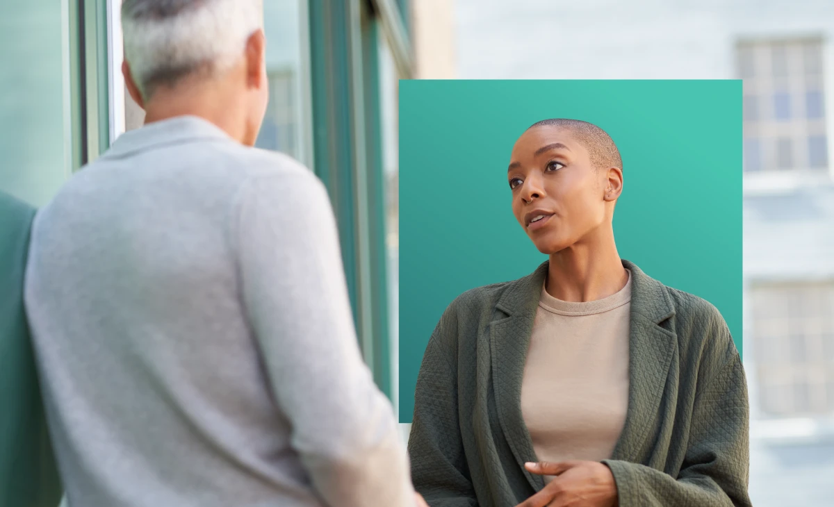 A female person talking to a male person outdoors.