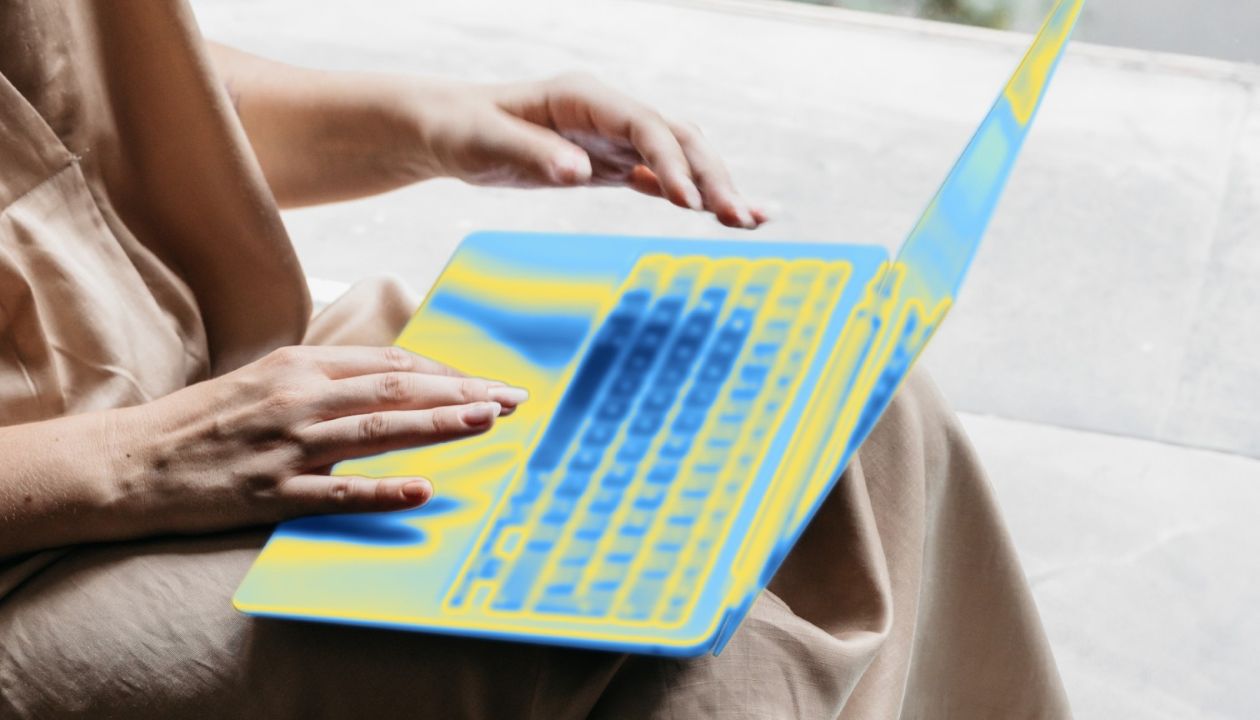 A person typing on a blue and yellow stylized laptop.
