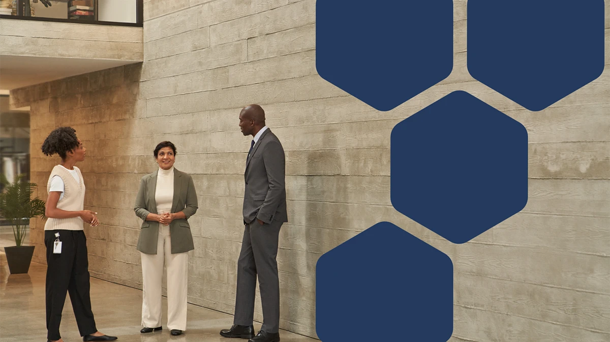 A man and two women standing in front of a wall