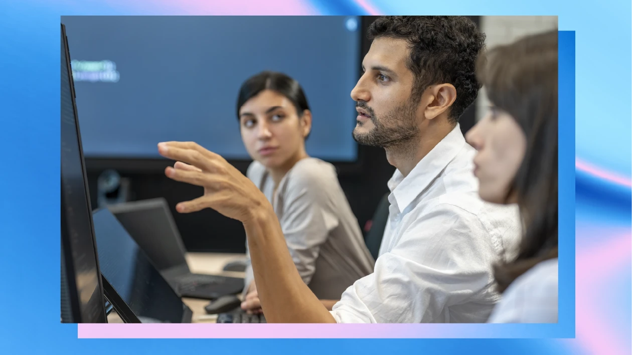 Three people sit at computers in a security operations center.